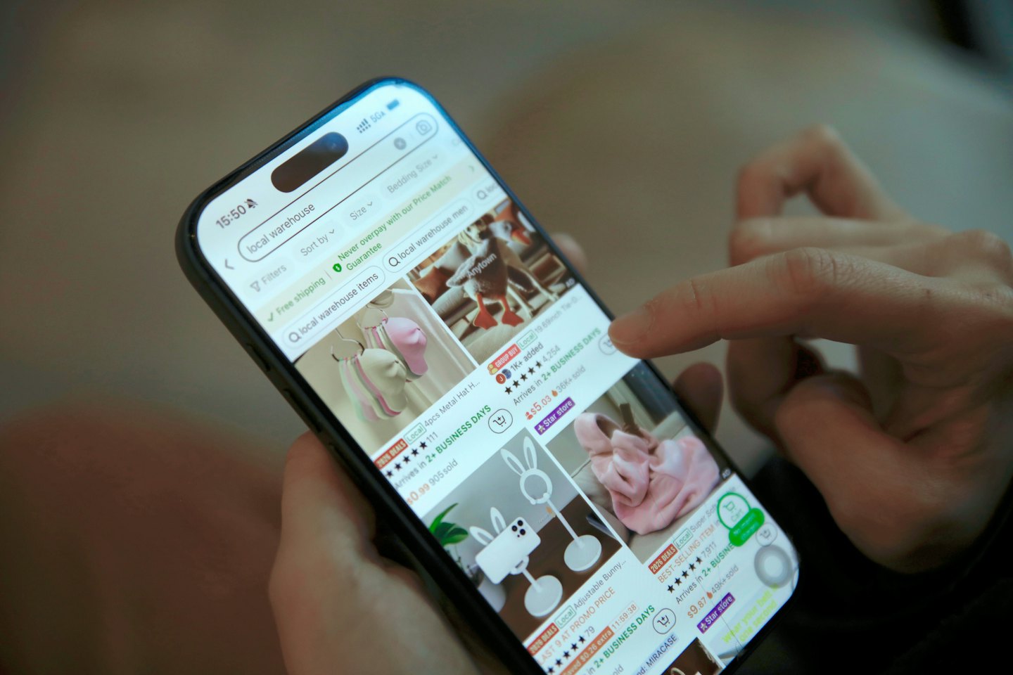 Manos tocando una aplicación de compras en línea en un teléfono inteligente.